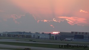 Rays of the sunset through clouds over the United airplane garage at O'Hare Airport.